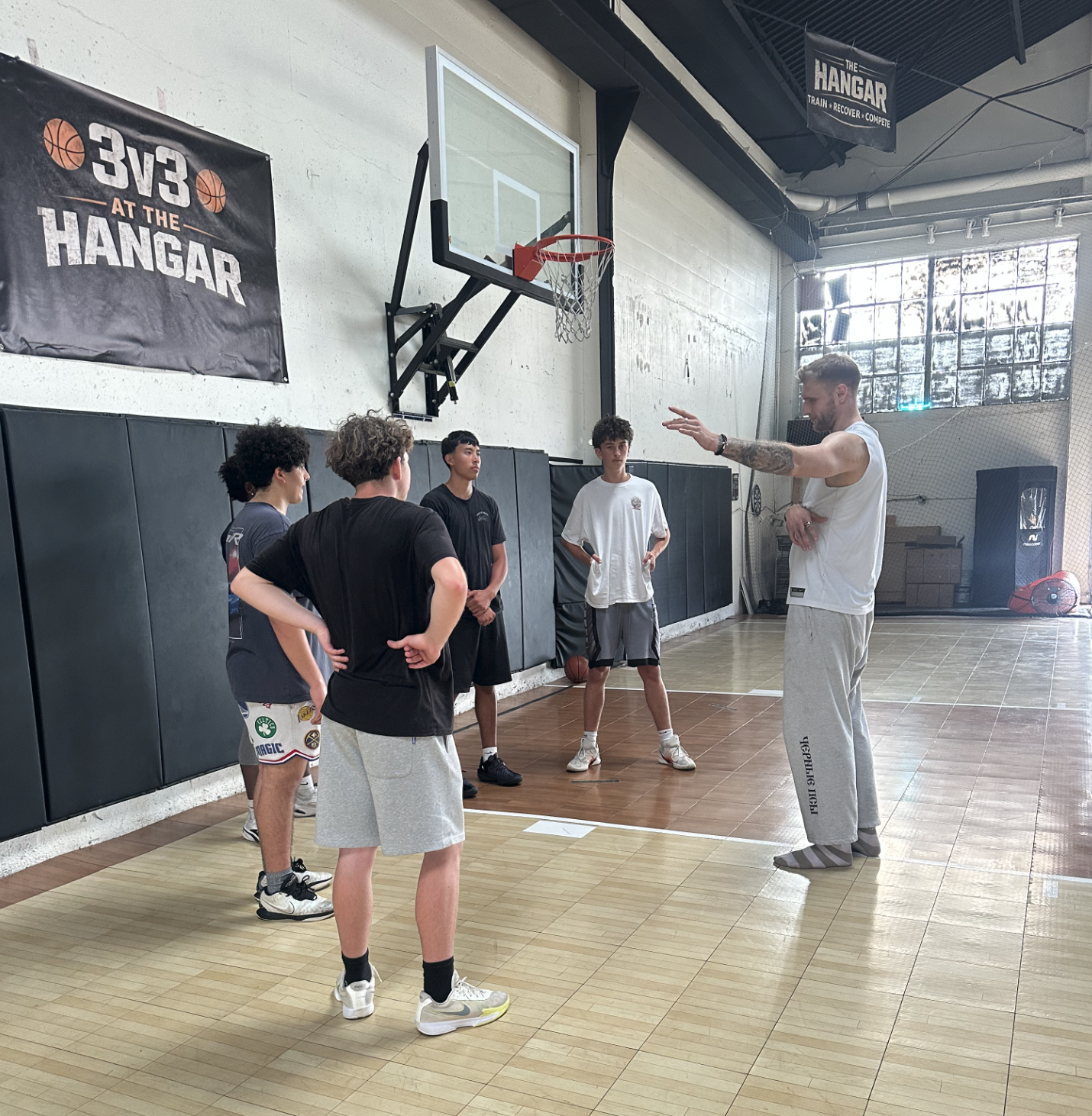 David Stronach coaching young basketball athletes on the court at The Hangar in San Diego California
