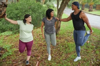 Three adults stretching before a run, illustrating research on uric acid and exercise training