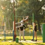 Adults using outdoor gym equipment, a common form of exercise participation in community settings
