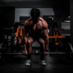 Athlete lifting a barbell in a gym, the back squat work used in resistance priming research