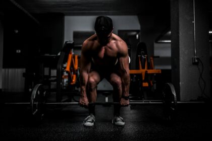 Athlete lifting a barbell in a gym, the back squat work used in resistance priming research