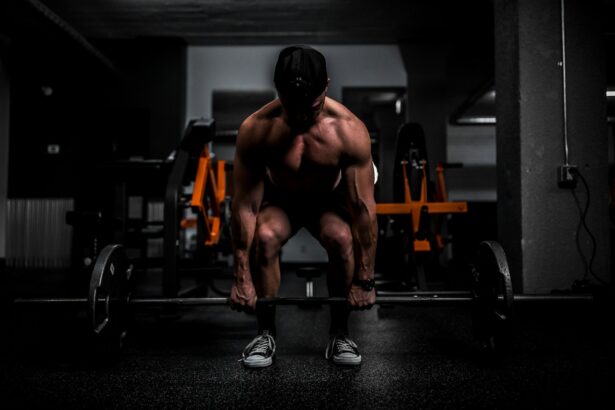 Athlete lifting a barbell in a gym, the back squat work used in resistance priming research