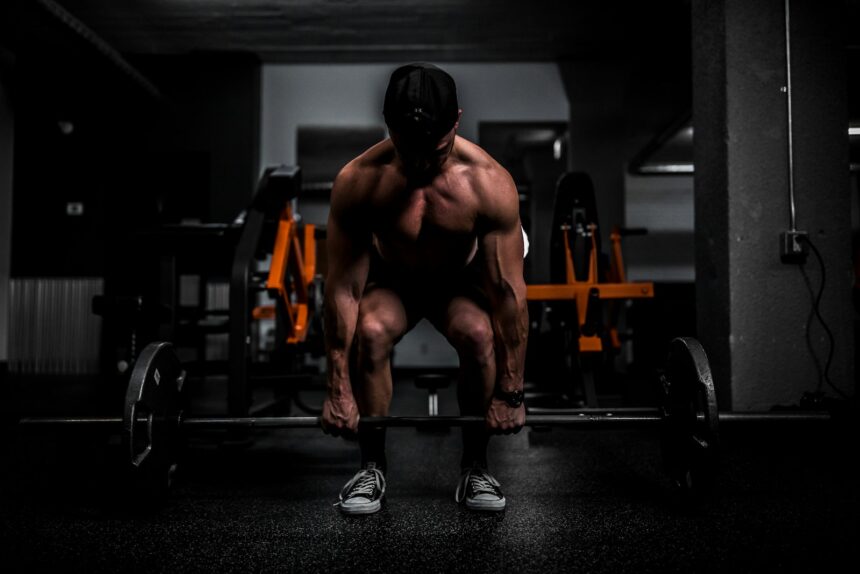 Athlete lifting a barbell in a gym, the back squat work used in resistance priming research