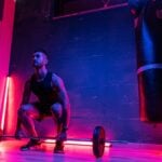 An athlete lifting weights in a gym, the training setting studied in cluster training research
