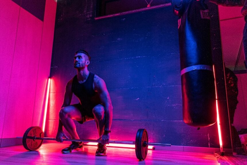 An athlete lifting weights in a gym, the training setting studied in cluster training research