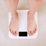 Person standing on a digital scale, illustrating body weight and body fat estimation