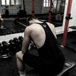 A coach supervising a young lifter, reflecting research on muscle growth in youth resistance training