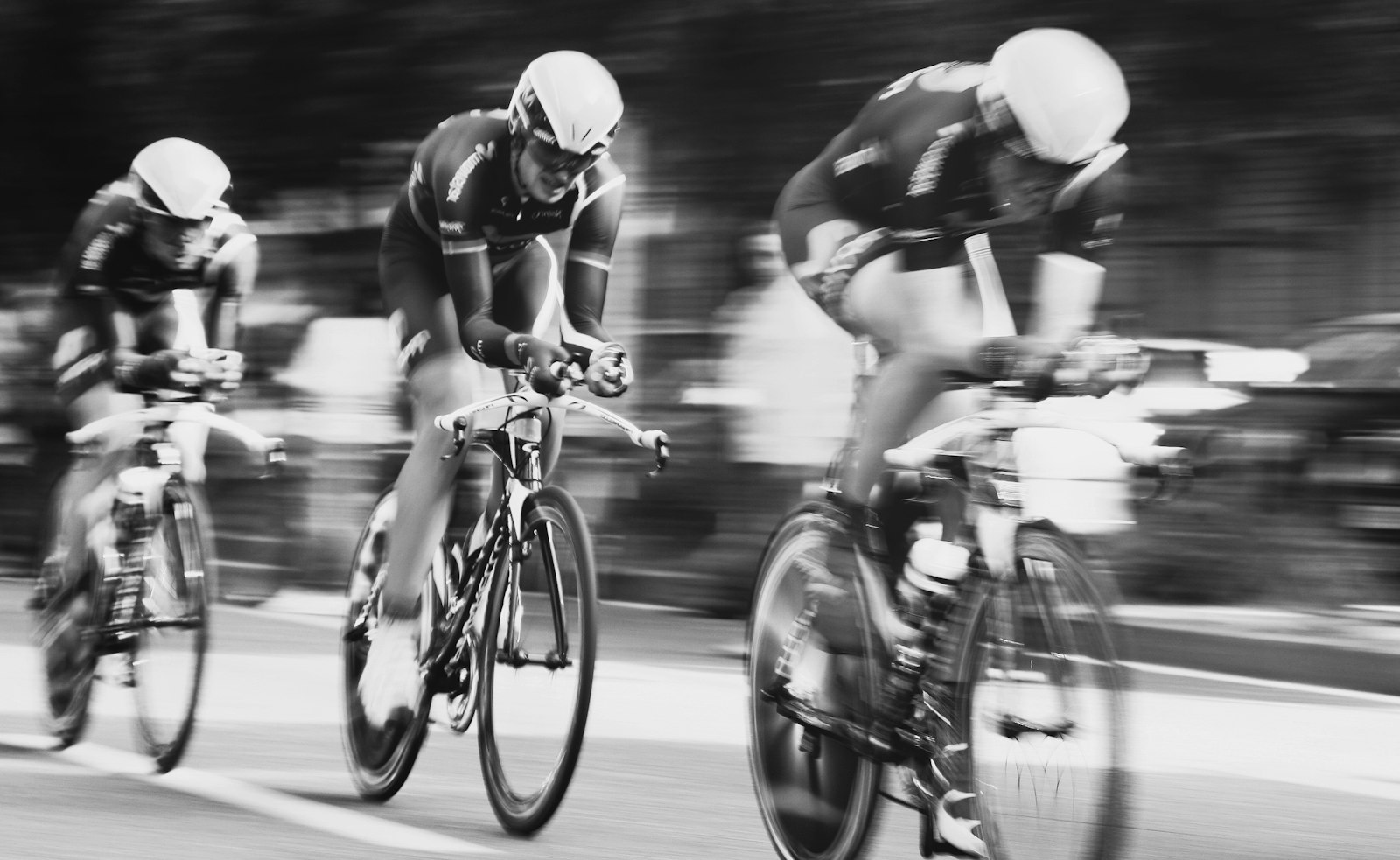 Three cyclists pedaling hard, illustrating muscle activation measured during incremental cycling