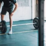 Athlete deadlifting a barbell in a gym, illustrating velocity-based deadlift 1RM testing