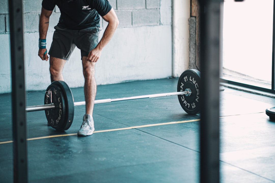 Athlete deadlifting a barbell in a gym, illustrating velocity-based deadlift 1RM testing