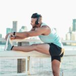 Athlete stretching a leg before running, illustrating muscle recovery after eccentric calf exercise