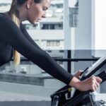 Woman exercising on a stationary bike during an indoor cycling workout