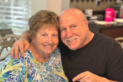 John DeFendis with his mother beside a birthday cake