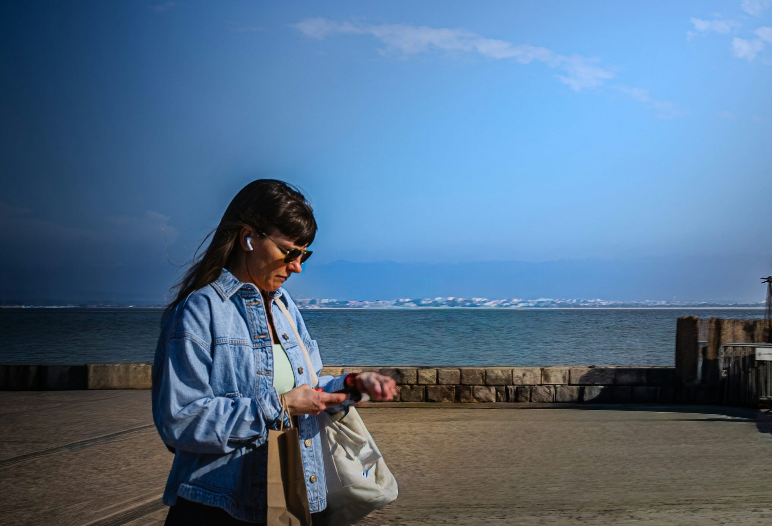 Woman checking a smartwatch during an outdoor walk, illustrating adaptive exercise prompts and wearable activity tracking