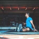 Man seated on an exercise mat stretching after resistance training