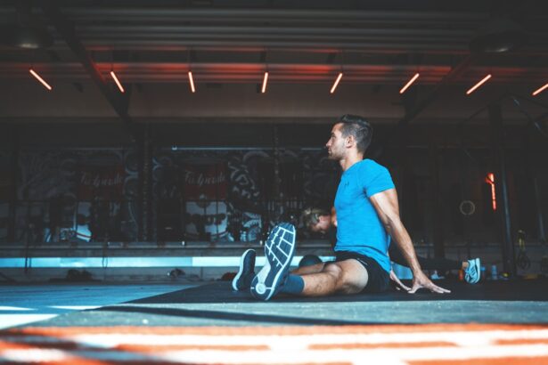 Man seated on an exercise mat stretching after resistance training