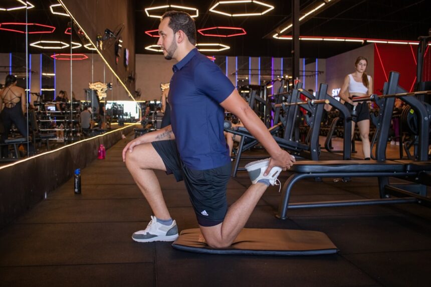Athlete performing a lower-body strength exercise with a trainer, illustrating quadriceps and joint positioning