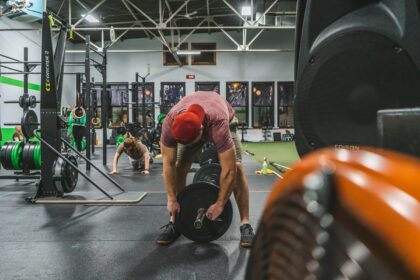 Man squatting in a strength gym, illustrating rest intervals during resistance exercise