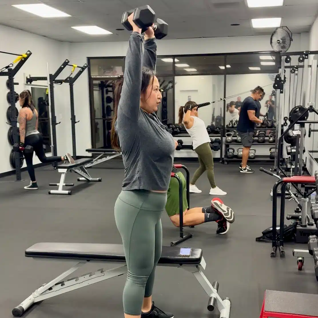 Members using dumbbells and other strength equipment at Sculpt Fitness