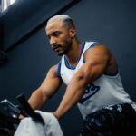 Athlete performing sprint interval exercise on a stationary bike in a gym