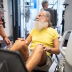 Older man exercising in a gym, illustrating supervised aerobic and resistance training during prostate cancer treatment