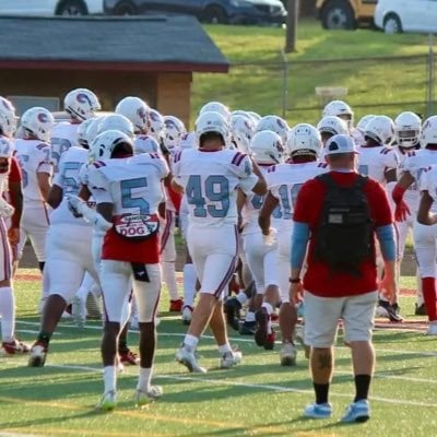 Football players and a coach on a field, from Trent Strickland’s public profile