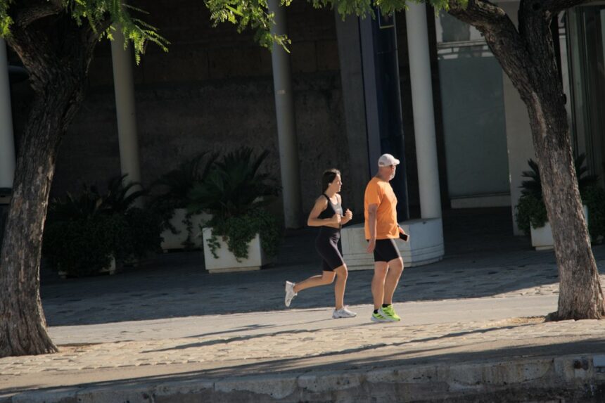 Two adults running along a street, reflecting the everyday habits behind cardiorespiratory fitness