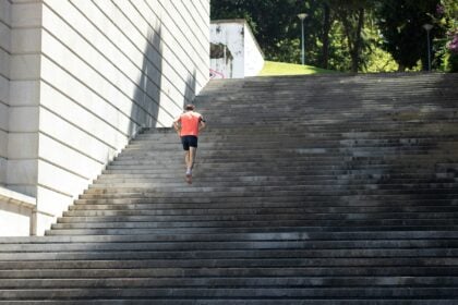 Man running up outdoor stone steps, illustrating vigorous activity and lower mortality risk