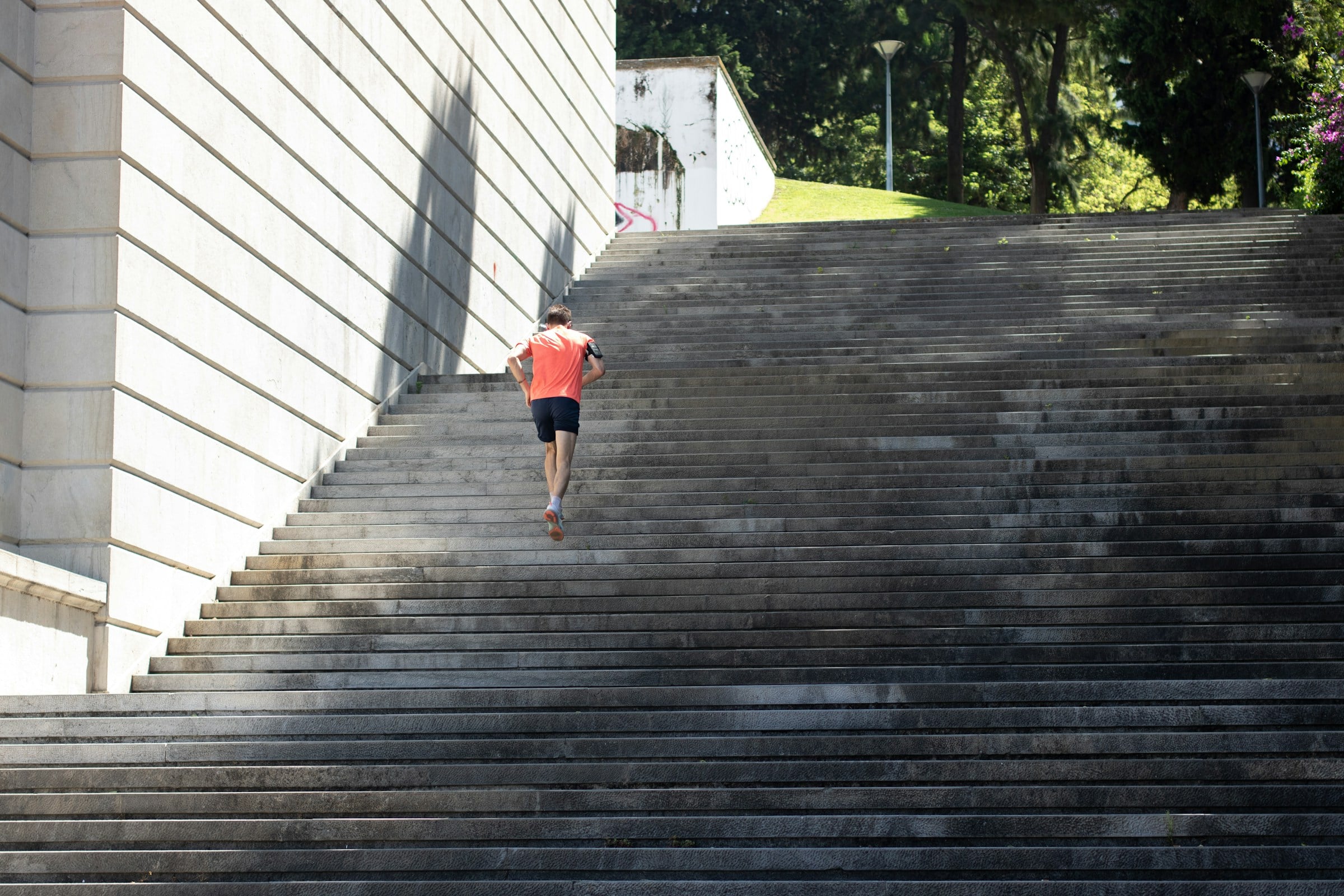 Man running up outdoor stone steps, illustrating vigorous activity and lower mortality risk
