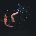 A woman lifting weights in a gym during a set of resistance exercise