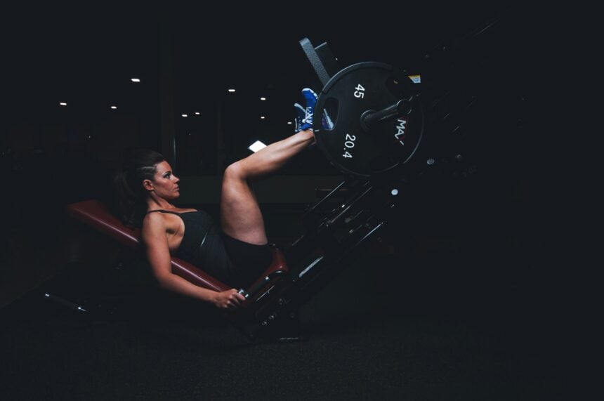 A woman lifting weights in a gym during a set of resistance exercise