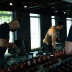 Adults lifting weights in a gym, illustrating exercise trials in adults with metabolic syndrome