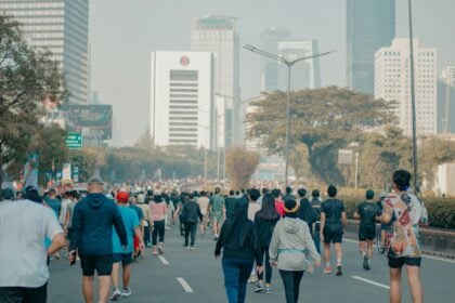 Adults running outdoors, the kind of movement wearable metrics record as steps and distance