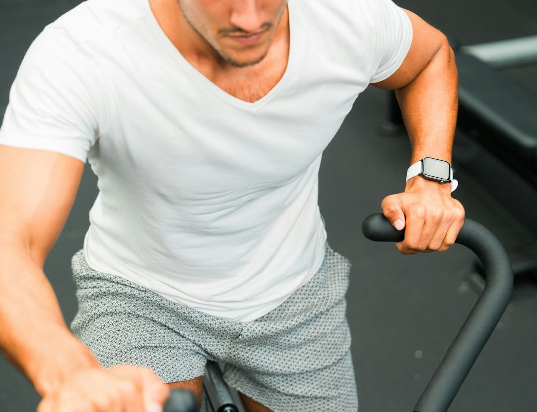Adult cycling on a gym stationary bike, the kind of aerobic training linked to better endothelial function