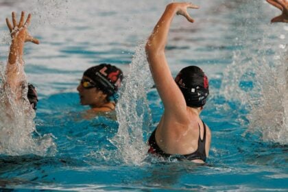 Two artistic swimmers training in a pool, the setting of a two-season injury surveillance study