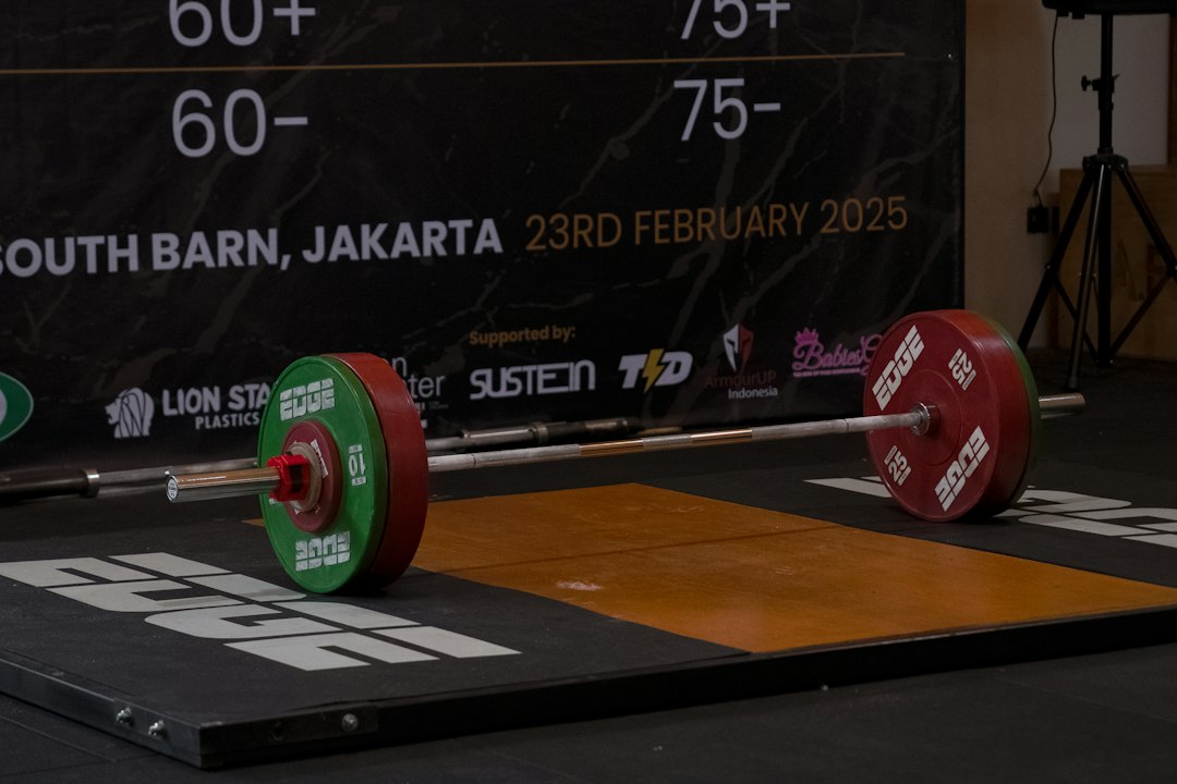 A loaded competition barbell on a lifting platform of the kind elite powerlifters compete on