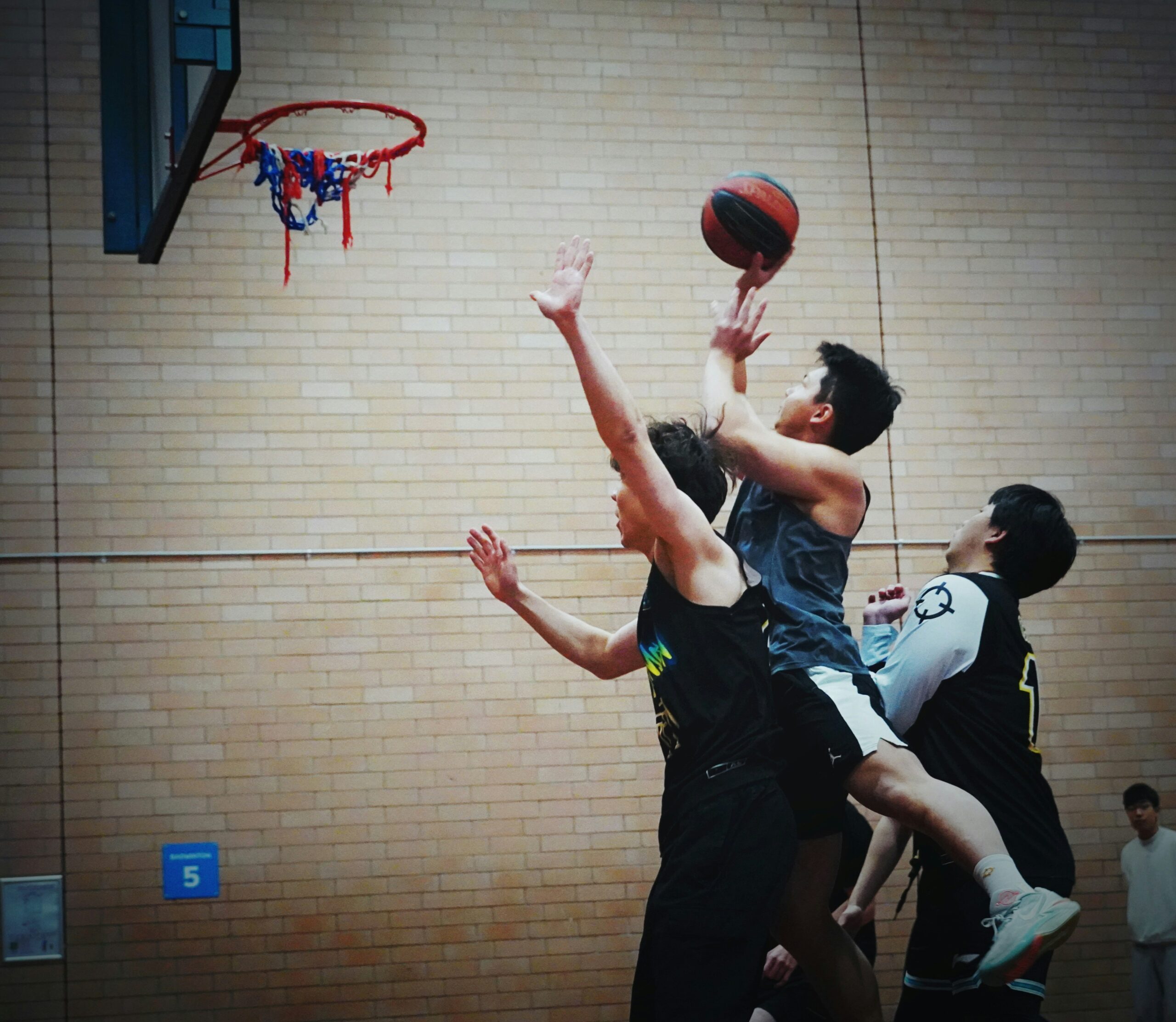 Basketball players jumping and landing indoors, a movement pattern tied to knee ligament injuries