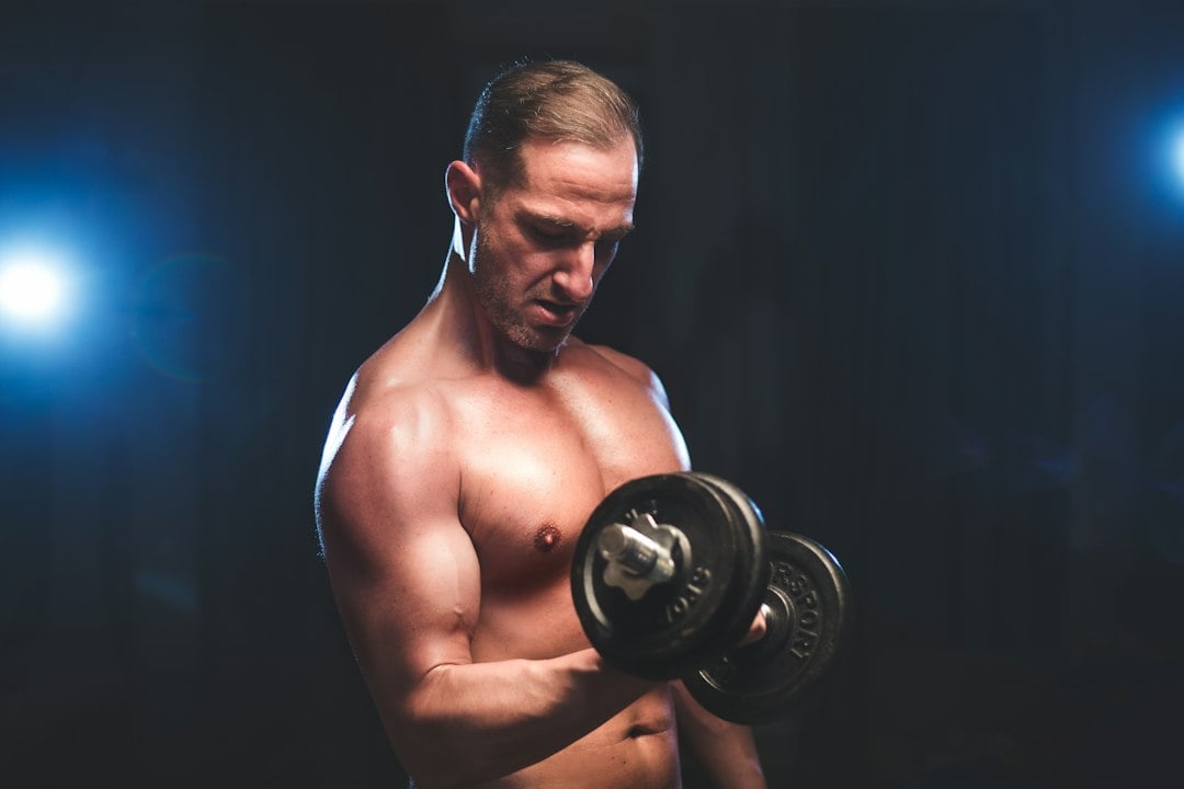 Lifter working through a dumbbell set, the training pattern paired with creatine supplementation in the 12-week trial