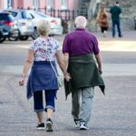 An older couple walking outdoors, the kind of habit linked with slower functional decline after age 50