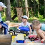 Preschool activity on an outdoor playground as young children run and climb