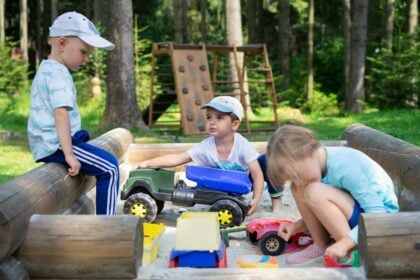 Preschool activity on an outdoor playground as young children run and climb