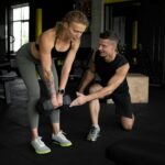 Two adults training with weights in a gym, illustrating the supervised exercise behind diabetes remission research