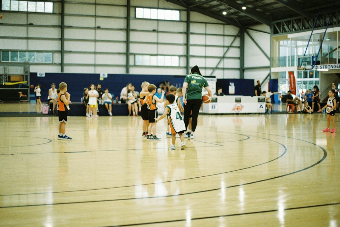 Adolescent basketball players moving through drills in a gymnasium during a warm-up program
