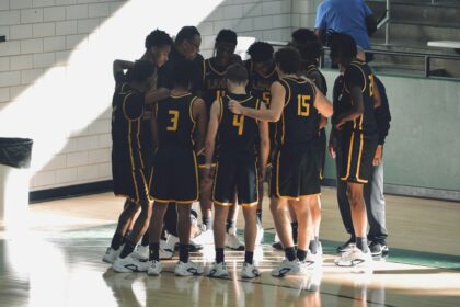 Youth basketball team huddled on the court before starting a warm-up program