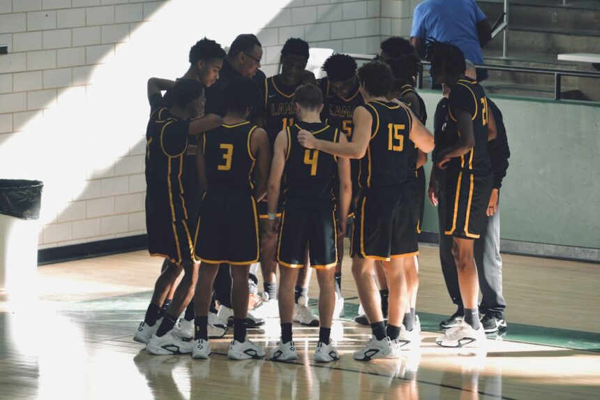 Youth basketball team huddled on the court before starting a warm-up program